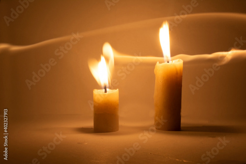 Photo of a burning candle with a yellow flame 