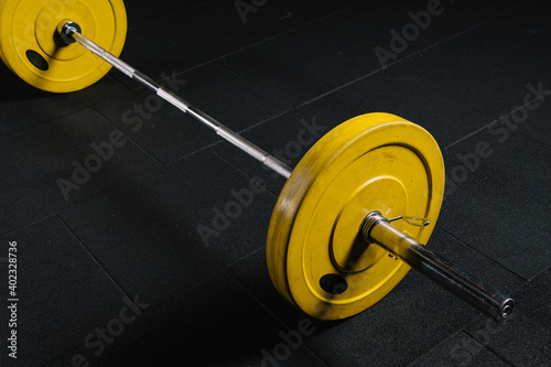 In the gym, the barbell stands on the floor.