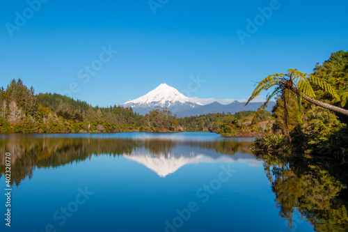 Lake Mangamahoe surrounded by native forest with stunning reflection of Mt Taranaki, North Island, New Zealand