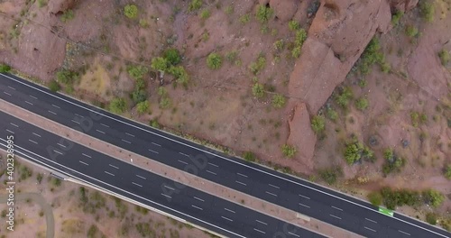 Cars moving quickly along road on interstate highway in desert and mountain landscape in United States of America