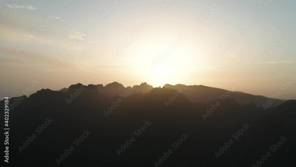 Bright sunset over silhouette mountains of Madeira island, aerial Bright sunset over silhouette mountains of Madeira island, aerial