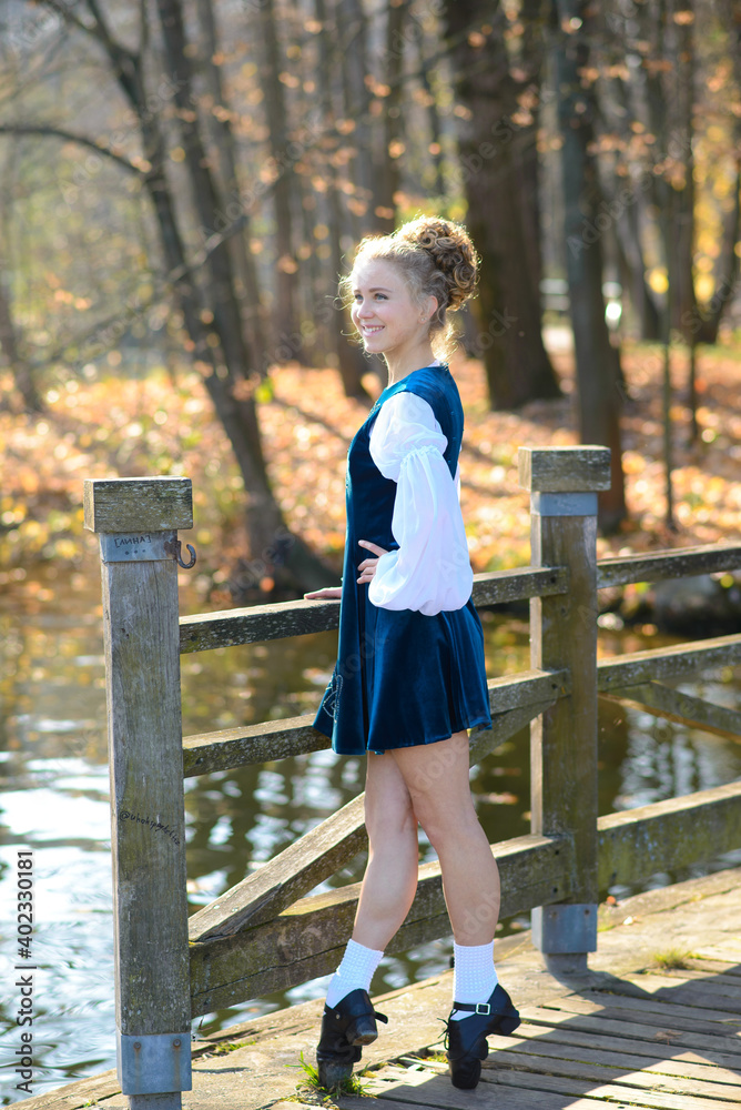 Ballerina dancing in nature among autumn leaves.