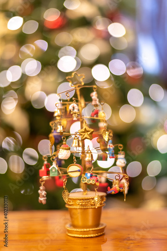 Close up of a christmas decoration with an illumintated christmas tree in the background photo