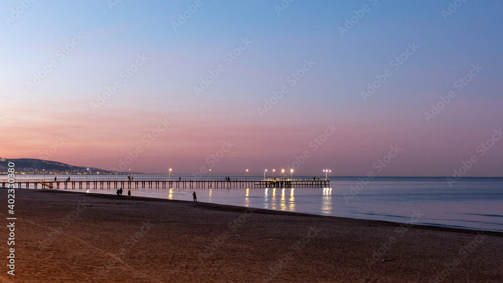 sunset on the beach, pier and sea on the sunset