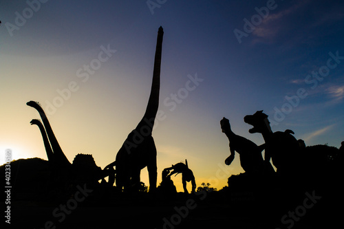 Dinosaurs in black silhouette on the sky background © titipong8176734