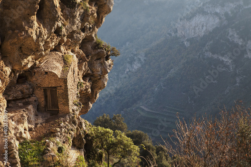glimpse of a stone cabin embedded in a rock wall along the Path of God ( Il sentiero degli dei) mediterranean landscape, Campania, Southern Italy, Europe.