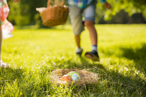 Cute boy and girl celebrating Easter, searching and eating chocolate eggs. Happy family holiday. Happy kids laughing, smiling and having fun. Beautiful spring sunny day in park