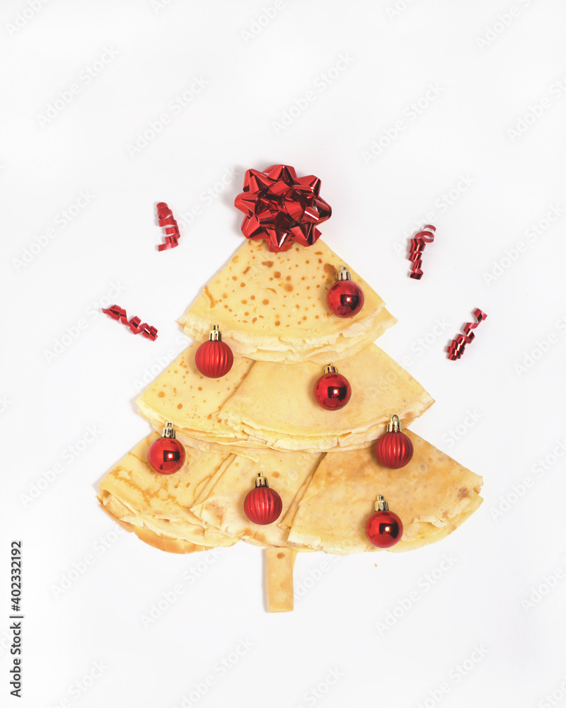 Christmas tree made of pancakes with red ornaments and red bow at the top of the tree celebrating