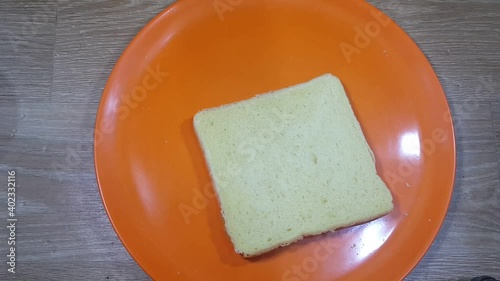 Slices of white bread falling on a pink plate.