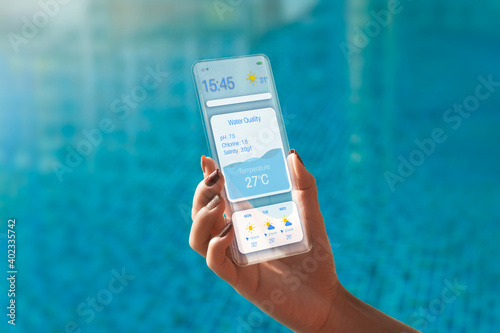 Transparent Smartphone. The Woman Use a futuristic design phone to check water quality in a swimming pool  . future technology and business concept . 