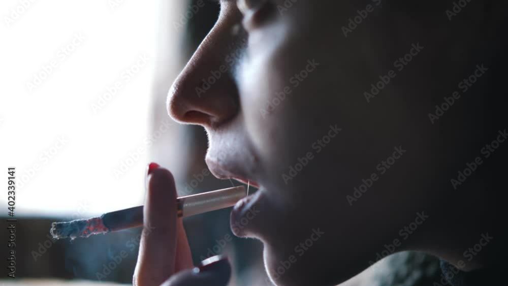 Close up of young woman smoking medical marijuana joint