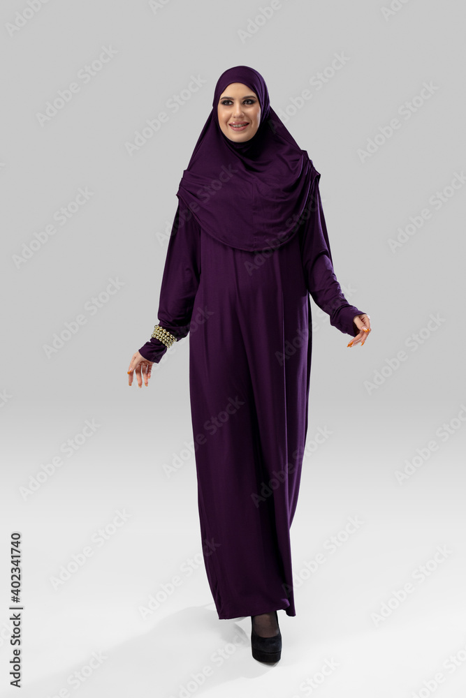Purple. Beautiful arab woman posing in stylish hijab isolated on studio background with copyspace for ad. Fashion, beauty, style concept. Female model with trendy make up, manicure and accessories. Purple. Beautiful arab woman posing in stylish hijab isolated on studio background with copyspace for ad. Fashion, beauty, style concept. Female model with trendy make up, manicure and accessories.