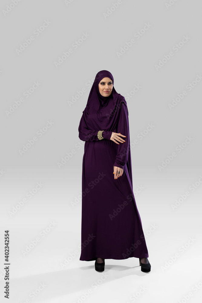 Queen. Beautiful arab woman posing in stylish hijab isolated on studio background with copyspace for ad. Fashion, beauty, style concept. Female model with trendy make up, manicure and accessories. Queen. Beautiful arab woman posing in stylish hijab isolated on studio background with copyspace for ad. Fashion, beauty, style concept. Female model with trendy make up, manicure and accessories.