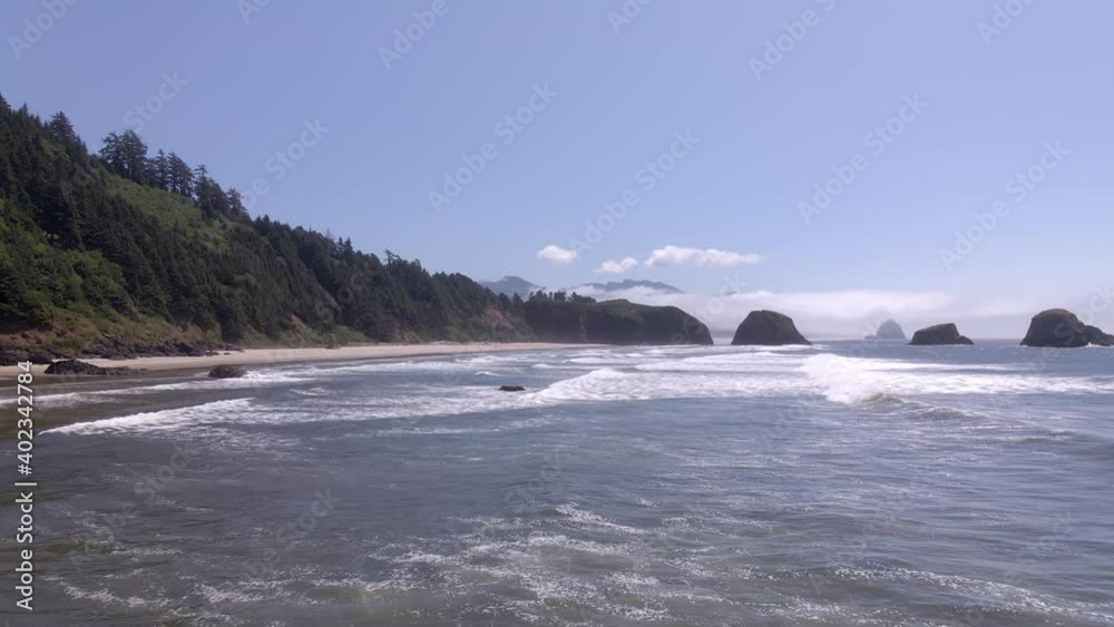 Drone flies parallel to the shore over breaking waves on secluded beach Drone flies parallel to the shore over breaking waves on secluded beach
