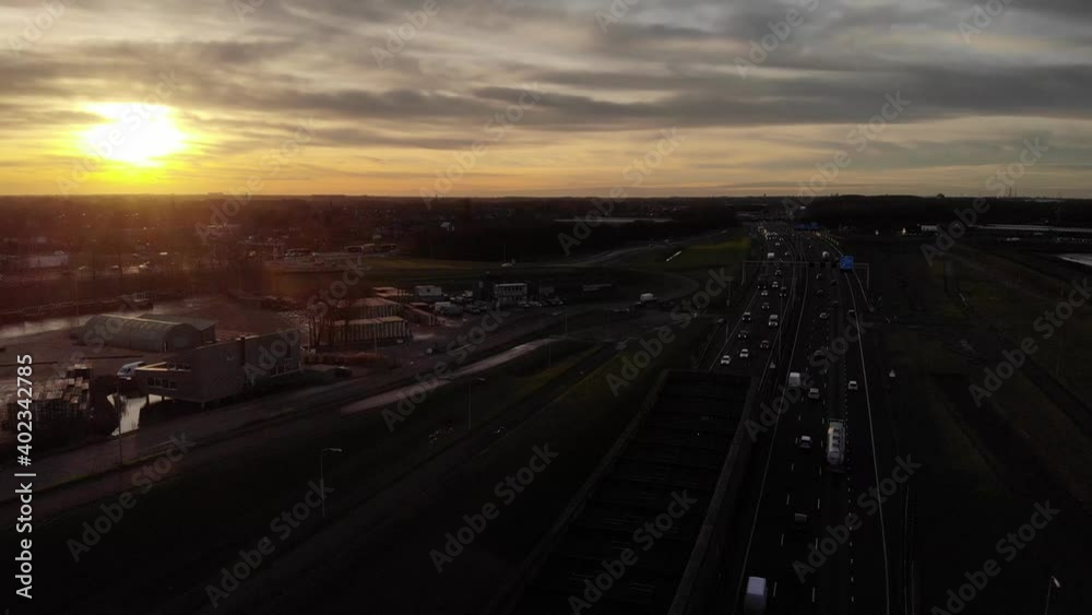 Sunset over highway with passing traffic driving into underpass. Drone. Sunset over highway with passing traffic driving into underpass. Drone.