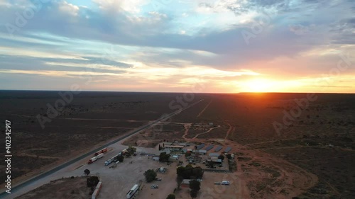 Aerial view of a roadhouse and motel, during sunset, in Australian outback - reverse, drone shot