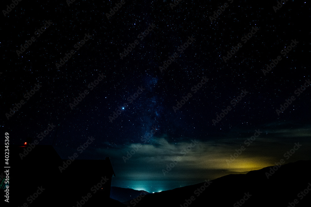 Fototapeta premium Starry sky surrounded by mountains
