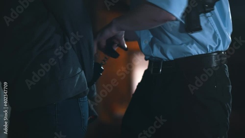 Close up of police officer arresting criminal and putting on handcuffs