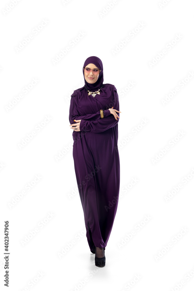 Dancing. Beautiful arab woman posing in stylish hijab on studio background with copyspace for ad. Fashion, beauty, style concept. Female model with trendy make up, manicure and accessories.