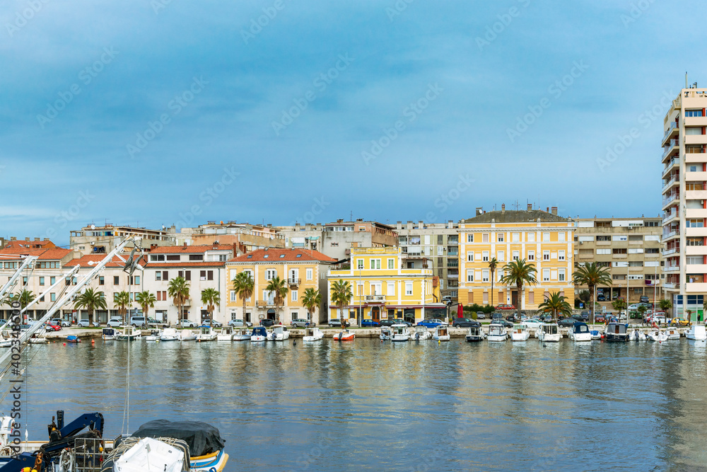 Scenic view of the Zadar city embankment with palm trees and moored boats, Croatia.