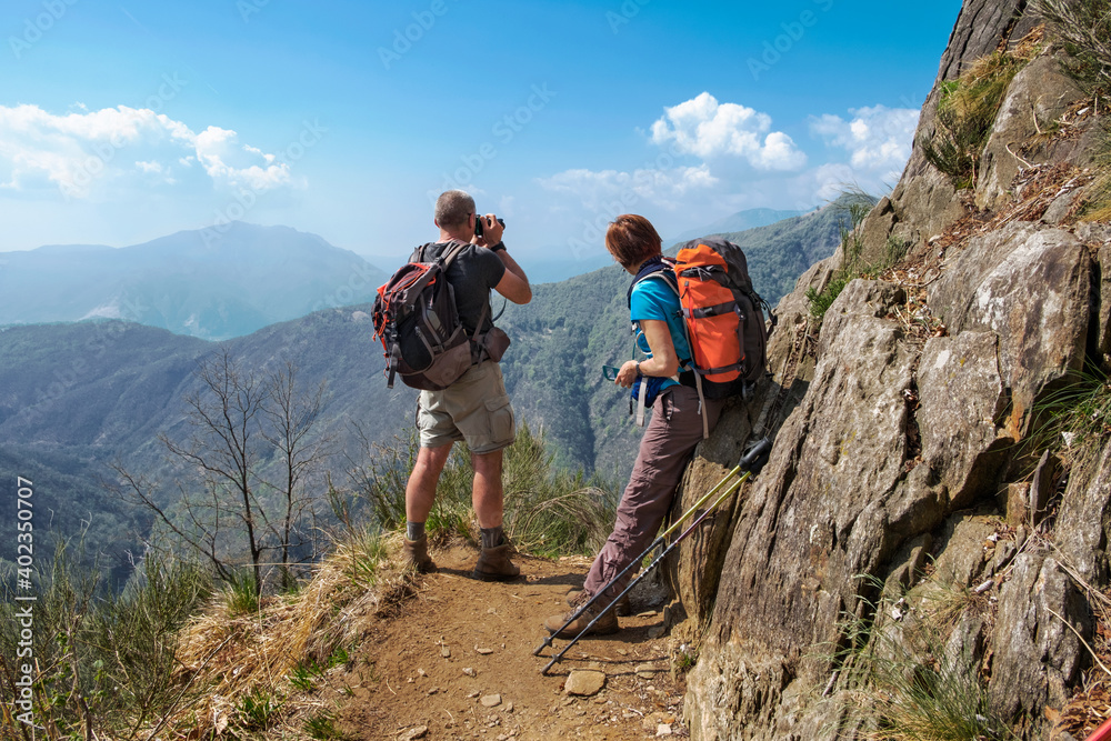 Couple of hikers taking picture and looking the beautiful panorama of  the wild Val Grande National Park, Europe, Piedmont, Italy.