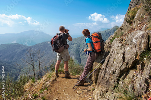 Couple of hikers taking picture and looking the beautiful panorama of  the wild Val Grande National Park, Europe, Piedmont, Italy. © Francesca