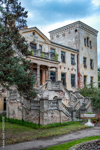 Staircase with stone railing. Entrance group in abandoned mansion and shabby facade. Kalkune manor in Latvia  example of Neoclassical architecture.