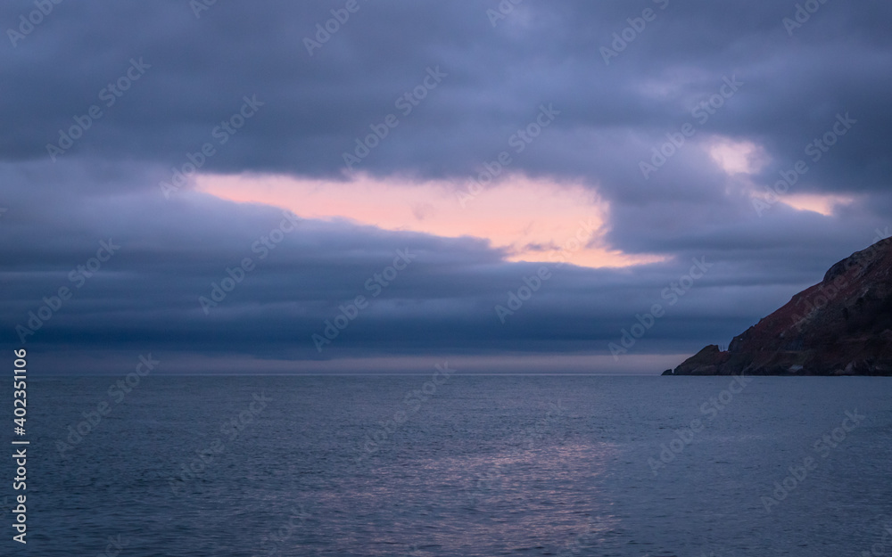 Nose of Bray Head with Pink Light Breaking Through Dark Clouds
