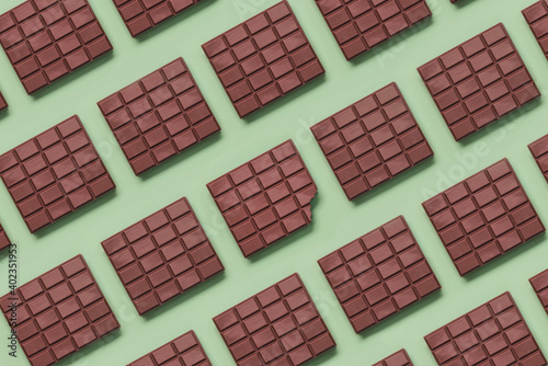 Geometric pattern made with chocolate bars and in the center a bitten tablet photo