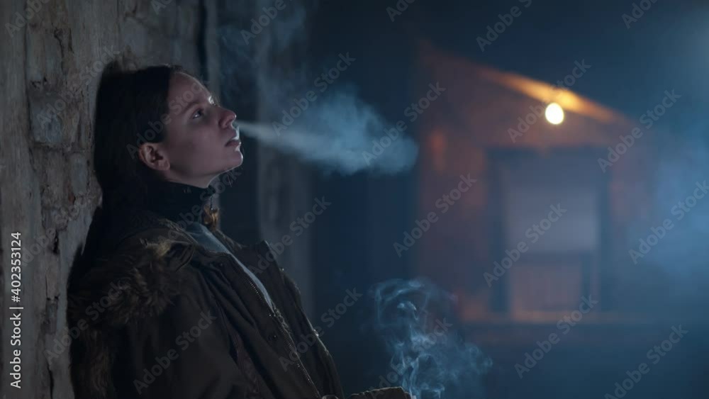 Junkie woman smoking marijuana cigarette white sitting on floor