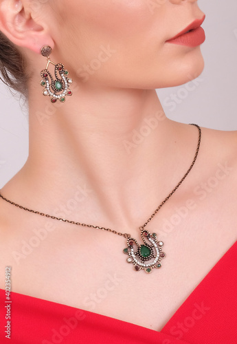 Beautiful female model wearing a necklace and earrings set with sawaroski and emerald stones