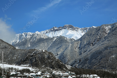 Mountain view of the village. The leaves of the trees fell on the mountain. It snowed in the mountains and in the village. Bash Dashagil village of Oguz region.Blue sky . It snowed in the village.