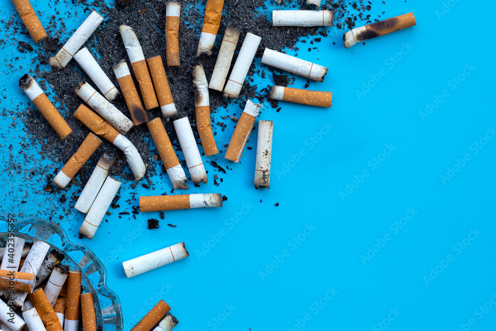 Cigarettes buds with ashtray on blue background. Cigarettes buds with ashtray on blue background.
