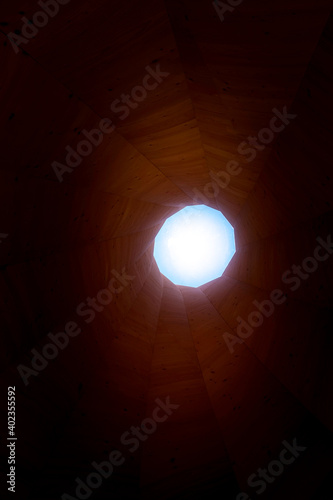 Tower or tunnel made of wood with wooden structures or light at the end of the tunnel
