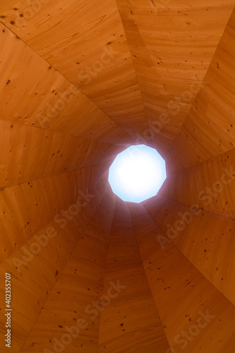 Tower or tunnel made of wood with wooden structures or light at the end of the tunnel