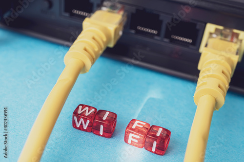 a router with yellow patch cords inserted into it and cubes on top of which wifi is written photo