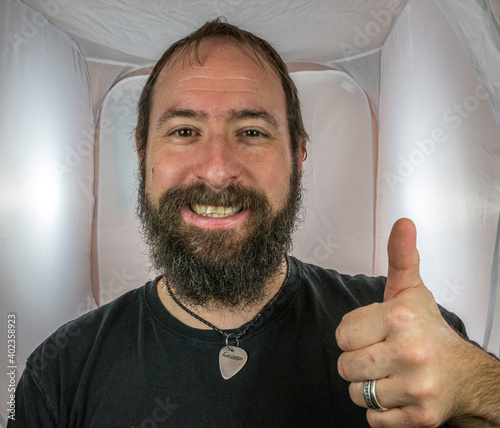 A bearded and smiling man showing respect and thumbs up photo