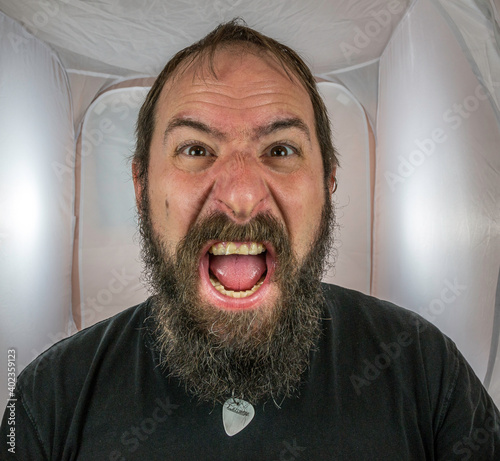 A bearded, shouting and angry looking man