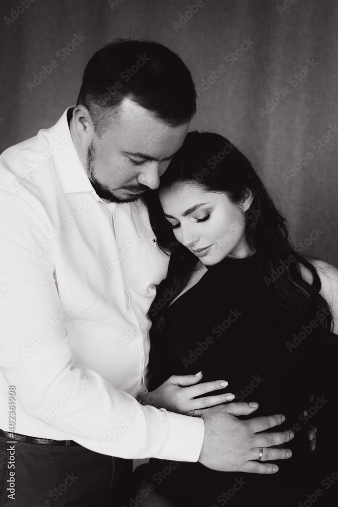 Pregnancy photo session in a photo studio with a fabric background in a black bodysuit and tights
Pregnancy photo session in a photo studio with a fabric background in a black bodysuit and tights