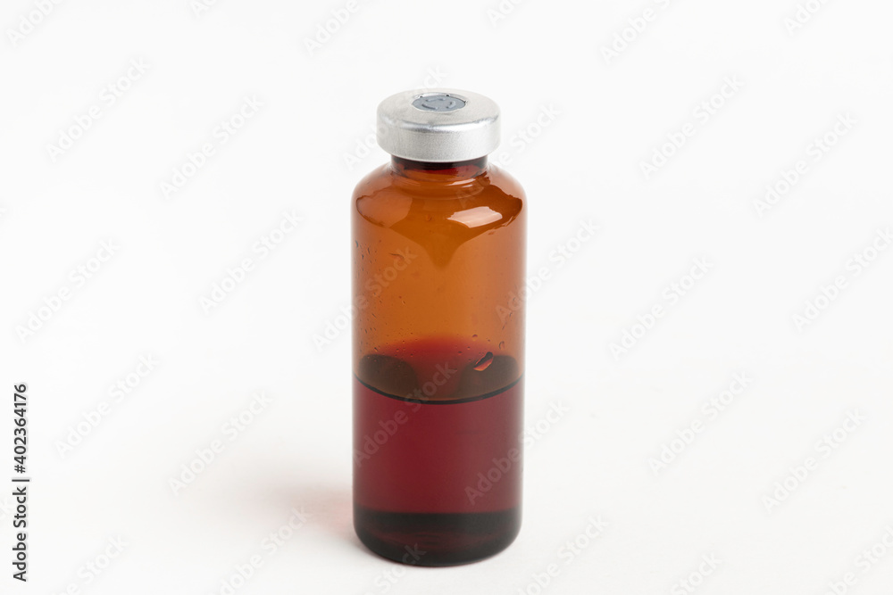 Obraz premium Macro Image Of Amber Vaccine Vial In White Background