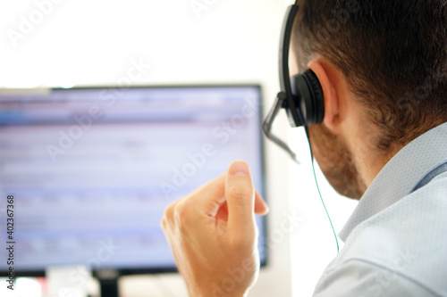 Male call center agent in headset consult client