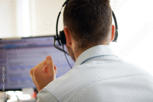 Male call center agent in headset consult client