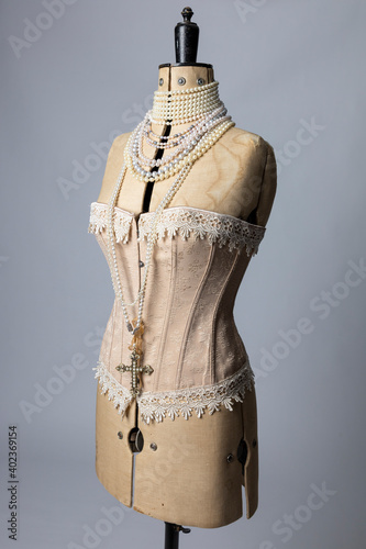 Fototapeta A vintage dressmakers dummy wearing a corset and pearl necklaces