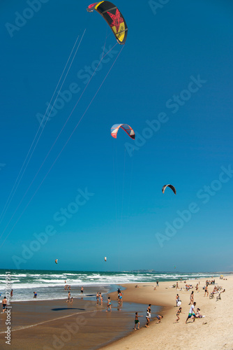 Kiteboarding or kitesurfing in Beach Park  beach. It is an extreme sport where the kiteboarder harnesses the power of the wind with a large controllable power kite to be propelled across the water.
