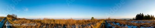 panorama of winter meadow  forest and clear sky in the mountains