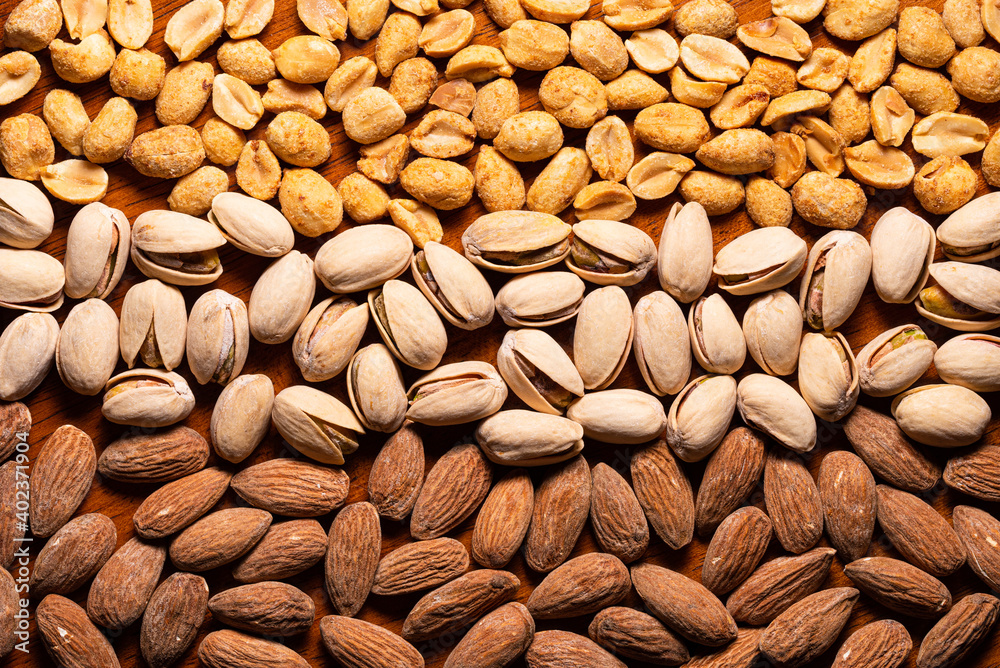 Pattern of pistachios, almonds, peanuts on wood table Pattern of pistachios, almonds, peanuts on wood table