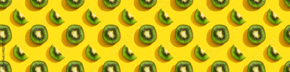 Fototapeta premium Kiwi seamless pattern on a yellow background.