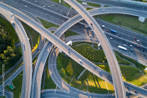 A modern flyover road junction in a large megapolis. Aerial photo from a drone from a altitude. Summer is a sunny day, sunset. 