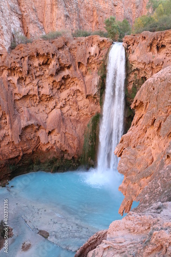 Wwaterfall into blue pool and red canyons