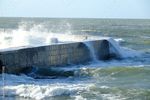 A wave hitting a pier at Batz-sur mer. West of France - december 2020